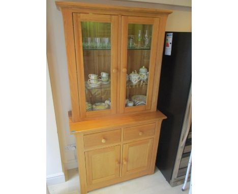 A modern light oak bookcase having twin glazed doors and drawers with cupboards below, 76 1/2"h x 40 1/2"w 