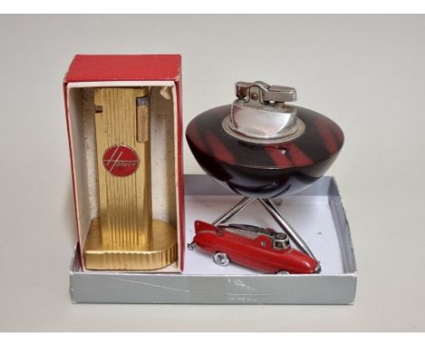 A Cygnus 'Hoover' table lighter,&nbsp;11cm high, boxed; together with two other novelty lighters, to include a Sarome example