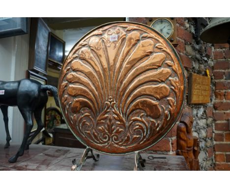 An embossed copper fire screen, 52cm diameter. 
