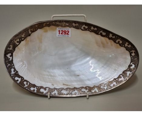 A large mother of pearl shell,&nbsp;with white metal rim, 28.5cm wide.&nbsp; 