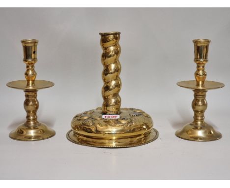A Dutch embossed brass candlestick, possibly 17th century, 19cm high; together with another pair of brass candlesticks. 
