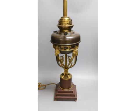 A gilt metal ‘rams head and hoof’ monopodia oil lamp, converted to electric, total height 72cm