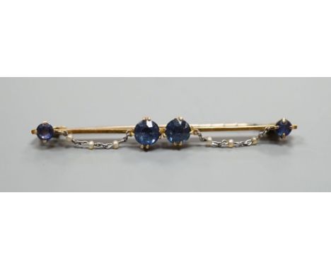 An early 20th century yellow metal sapphire and seed pearl set bar brooch, 61mm, gross weight 5.6 grams.