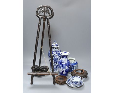 A Chinese Kangxi style blue and white teabowl and saucer, other oriental ceramics, carved hardwood easel, etc.