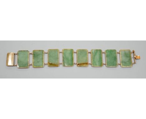 A 585 yellow metal and jade bracelet, set with eight rectangular panels, 18cm, gross weight 26.5 grams.