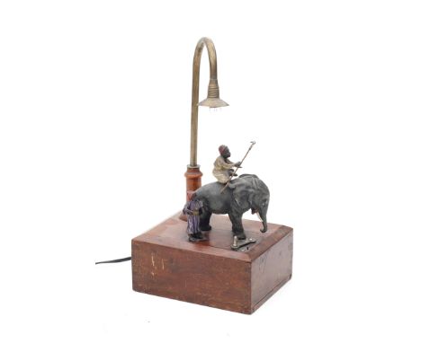 Vienna (attributed) A small table lamp with cold painted metal group of an elephant and two human figures, on wooden base, po