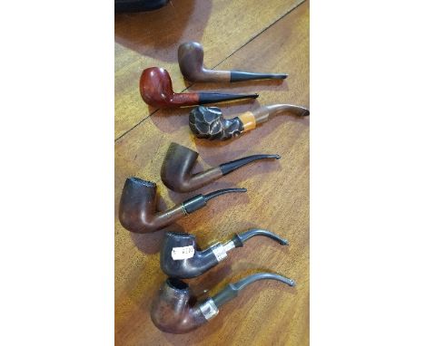 Two Peterson's of Dublin Pipes, one with Irish hallmarked silver band (on a stand), together with four Carey Magic Inch pipes