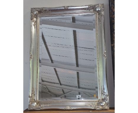 A Good Modern Wall Mirror having Bevelled Glass and an Ornate Silver Frame, 65cm x 90cm.