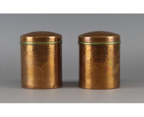 A pair of Keswick School of Industrial Arts planished copper cylindrical cannisters and covers, the lids with brass edging, e