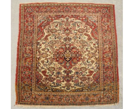 A Sarouk rug, woven with central medallion, spandrels and floral filler motifs on a pale tan ground, 192cm x 132cm Wear to si
