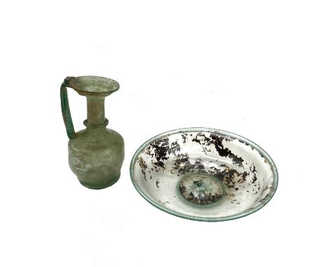 A Roman 2nd-4th century CE pale green glass shallow bowl with a dimple base and concentric circle foot and rim, diameter 15.5