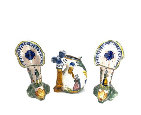 A pair of Quimper cornucopia vases, with hand painted decoration, height 16cm, together with a similar jug fashioned as a bag