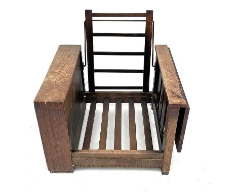 A Heals style oak reclining bookcase chair, with a drop leaf side, height 72cm, width 75cm, depth 77cm.Some areas of light wa