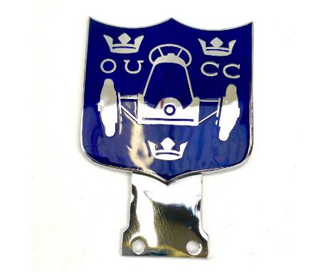 A 20th century chrome and enamel car badge inscribed O U(ohm) CC with three crowns around a racing car, height 10cm.