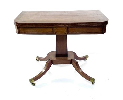 A Regency mahogany and inlaid fold top card table, with bands of lozenge inlay and stringing on a square tapering column and 