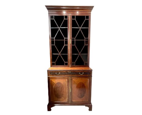 A late Victorian mahogany cabinet bookcase, in the Georgian taste, with a glazed upper part and a long drawer and two doors b