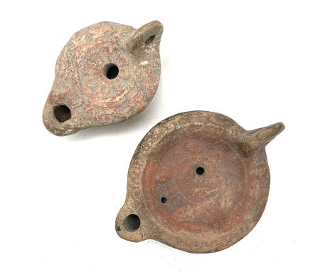 A Roman terracotta oil lamp moulded with wheat design diameter 10cm together with another Roman terracotta oil lamp. (2)