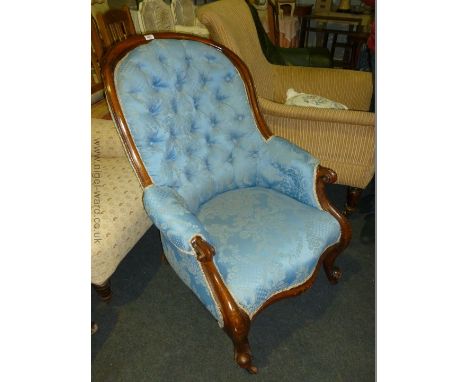 A Victorian Mahogany button back, scroll Armchair with blue damask upholstery, standing on cabriole legs.