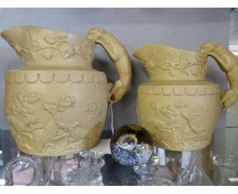 Two hunting jugs with raised decoration, the handles formed of dogs, along with a Caithness "moon crystal" paperweight