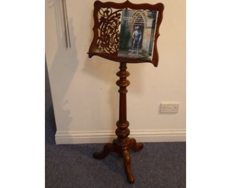 A mid-19th century adjustable walnut music stand, turned tapering fluted stem and on tripod base terminating in scrolls. Prov
