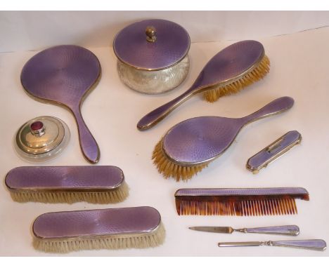 An early 20th century guilloche enamel and silver-mounted eleven-piece dressing table set comprising: powder bowl and cover, 