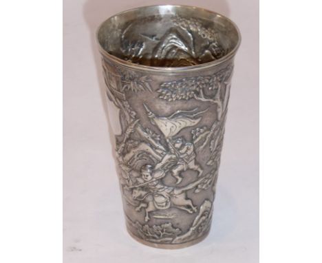 A 19th century tapering cylindrical Chinese silver beaker; vacant shield-shaped cartouche and a battle-scene in relief amongs