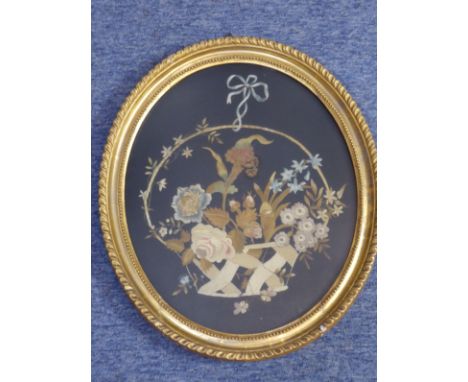 A 19th Century gilt framed and glazed (probably late Regency period) floral embroidery onto black silk, various flowers emana