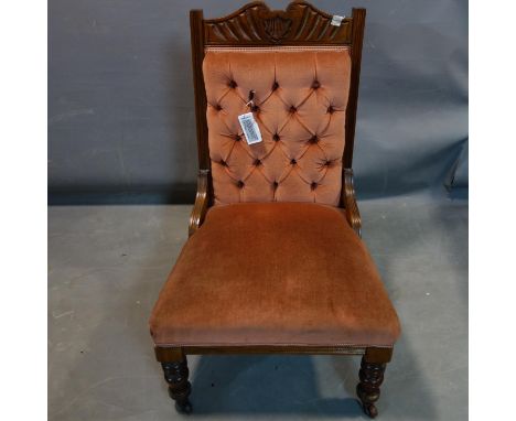 An Edwardian mahogany nursing chair with button back velour upholstery 