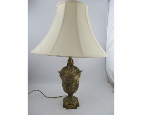 An early 20th century/late 19th century large table lamp, and shade, the gilt metal lamp with dancing cherubs all round and a