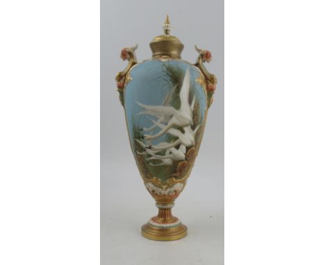 A Royal Worcester vase, the twin handled vase decorated with six Swans in flight to a powder blue ground by C H C Baldwyn, th