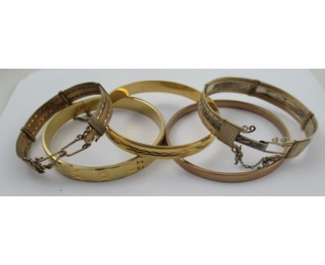 A gilt metal bangle, two other gilt bangles and two continental yellow and white metal bracelets&nbsp;