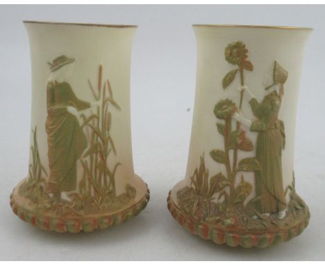 A pair of Royal Worcester blush ivory spill vases, decorated in relief with a shot silk figure in the Kate Greenway style, sh