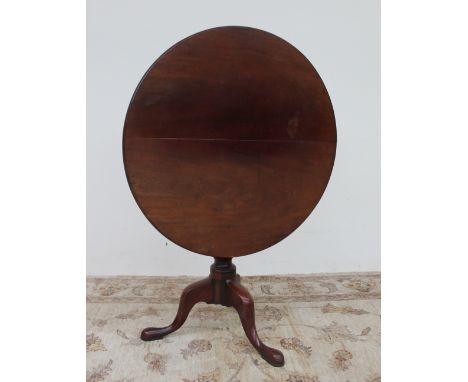 A George III mahogany tripod table, the circular top with a bird cage action on a baluster column and three legs with pad fee