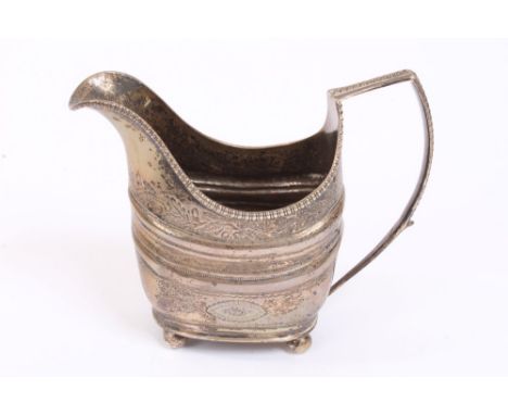 George III Irish silver cream jug of helmet form, with bright cut and banded decoration, gadrooned border and loop handle, on