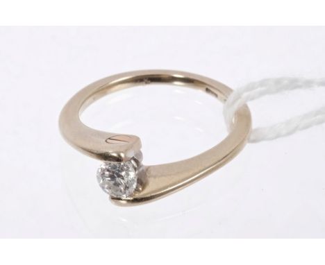 Diamond single stone ring with a brilliant cut diamond estimated to weigh approximately 0.28 carats, the crossover setting wi