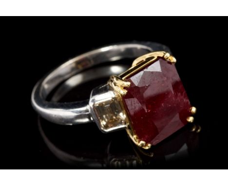 Ruby and diamond three-stone ring with a rectangular step cut ruby estimated to weigh approximately 6.30 carats, flanked by a