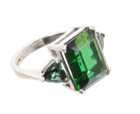 18ct white gold and green tourmaline three-stone ring with a central rectangular step cut stone measuring approximately 14.1m