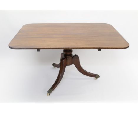 George IV mahogany breakfast table, the rounded rectangular hinged top on ring-turned column and hipped tripod supports with 