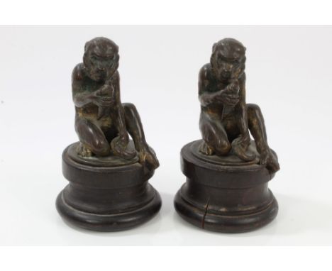 Pair of 19th century gilt bronze monkey sculptures - each modelled in seated pose, eating a root vegetable, raised on turned 