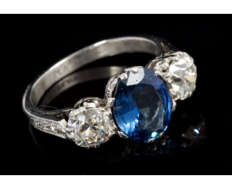 Sapphire and diamond three-stone ring with an oval mixed cut blue sapphire measuring approximately 9.0mm x 7.2mm x 3.85mm, fl