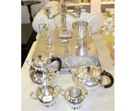 A silver plated wedding cake stand, chased and engraved overall; a silver plated four piece tea service; a silver plated cand