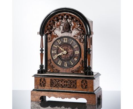 EARLY 20TH CENTURY CONTINENTAL CARVED OAK BRACKET CLOCK
with foliate carved arched pediment supported by two columns, on four