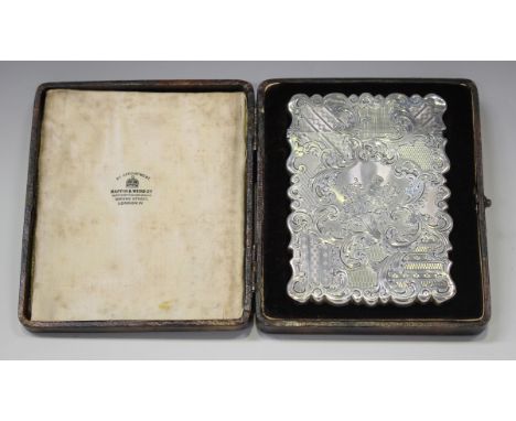 An early Victorian silver card case of shaped rectangular form with hinged cover, engraved with putto, cornucopia, foliate sc