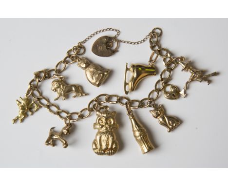 A 9ct gold curblink charm bracelet, fitted with nine 9ct gold charms, including a lion, four cats and a witch on a broomstick