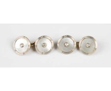 A pair of two colour gold, diamond and mother-of-pearl dress cufflinks, each back and front centred by a cushion cut diamond 