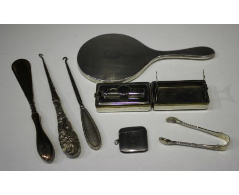 An Edwardian silver cased curling tongs heater box of rectangular form, the hinged lid embossed with cupids and scrolls surro