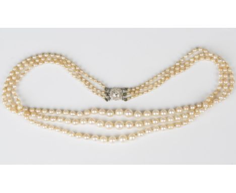 A three row necklace of graduated natural saltwater and cultured pearls on a diamond cluster clasp, collet set with the princ