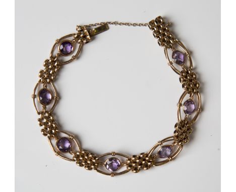A 9ct gold and amethyst bracelet, collet set with seven circular cut amethysts within oval wirework surrounds, alternating wi