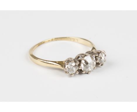 A gold and diamond three stone ring, claw set with the row of cushion cut diamonds, detailed '18ct', weight 2.4g, ring size a