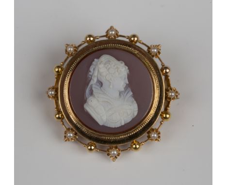 A gold mounted sardonyx brooch of circular form, carved with a profile head and shoulders bust portrait of a lady within a be